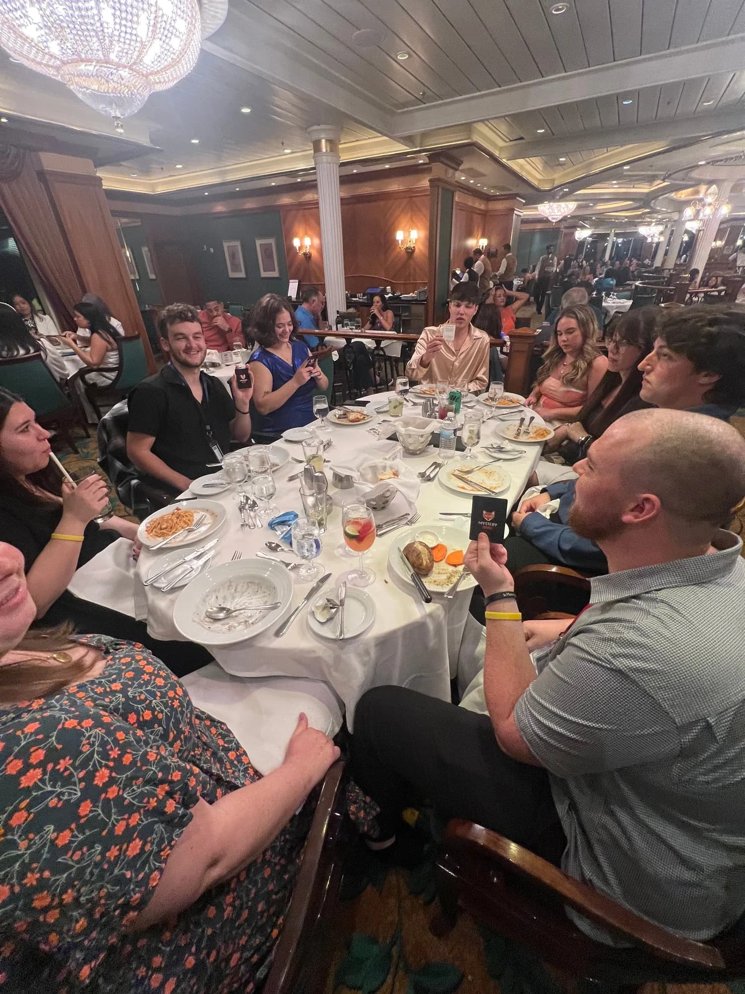 A large group seated along a long dinner table at a restaurant