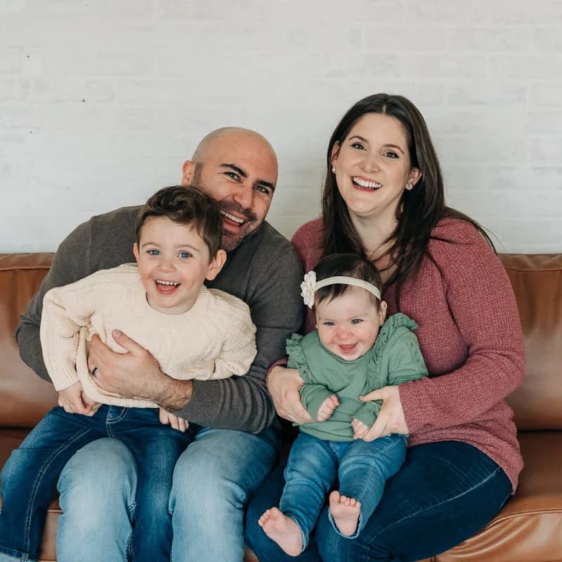 Spencer Siegel with his family, seated together on a sofa